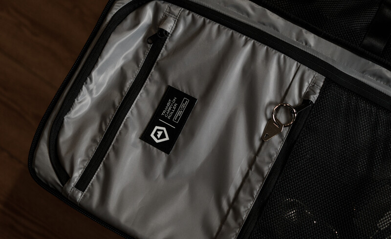 Interior of a camera bag showing a padded compartment with a small black gear tag and metal keyring attached.