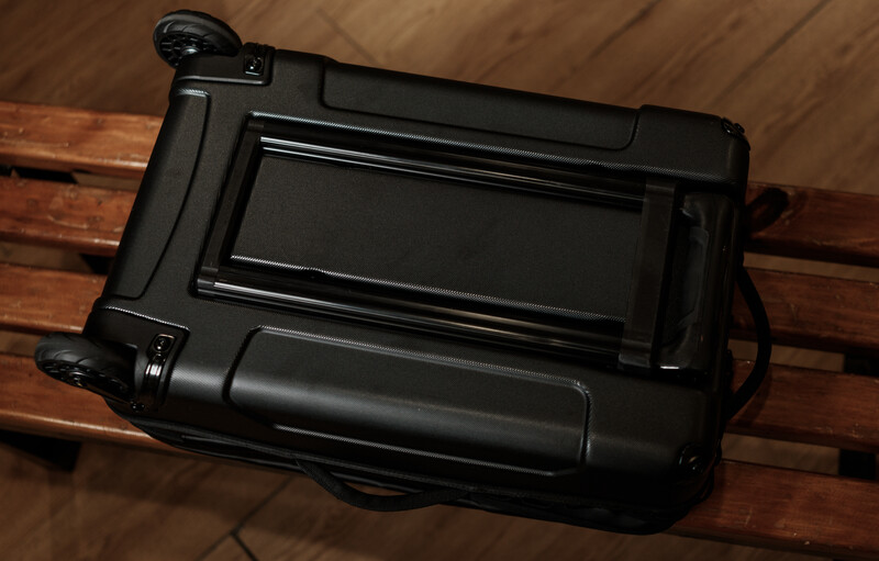 Black professional video camera with flip-out LCD screen viewed from above on wooden surface.