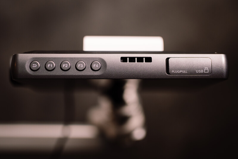 Close-up of camera control panel with five buttons, level indicator, and USB port labels.