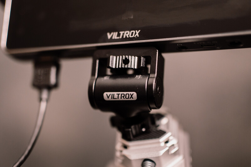 Viltrox hot shoe flash trigger mounted on camera with monitor above displaying Viltrox branding.