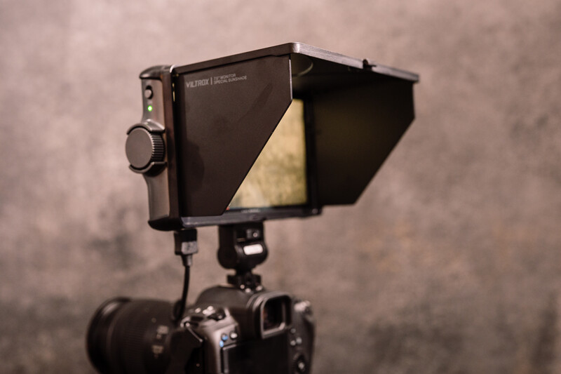 Professional on-camera monitor with sunshade mounted on camera using articulating arm.
