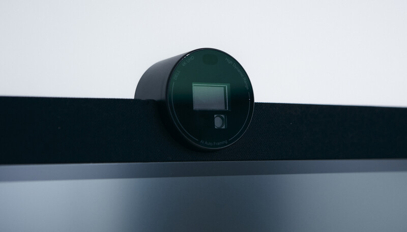 Dark spherical camera mounted on a black horizontal rail against a light gray wall.