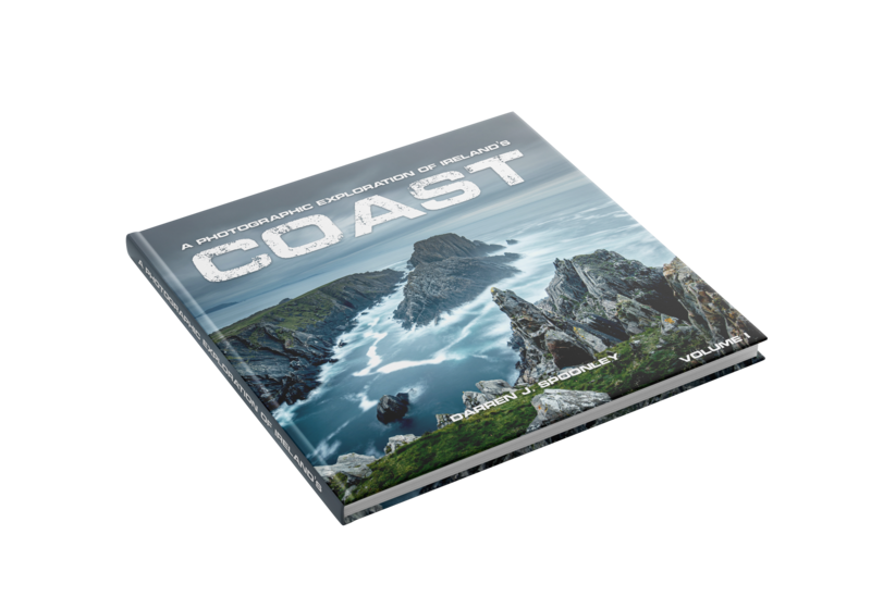 Hardcover book titled 'Coast' displaying a dramatic mountain landscape photograph on its cover.