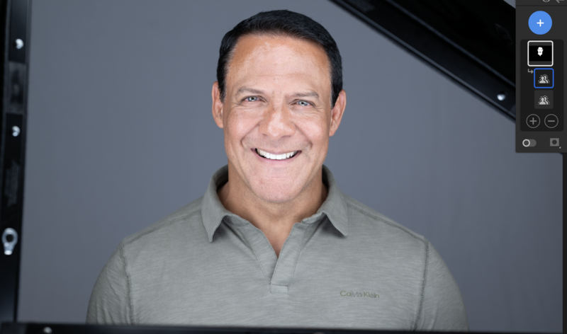 Professional headshot of a man wearing a gray polo shirt against a neutral gray background.