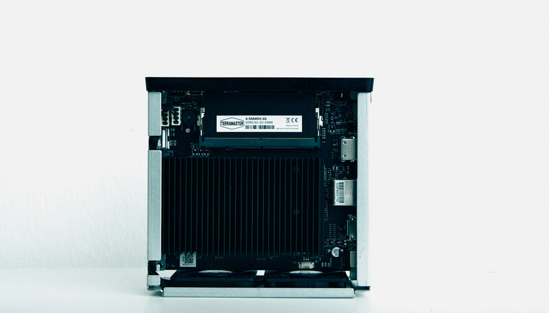 Internal view of a computer tower showing circuit board components and cooling fins against white background.