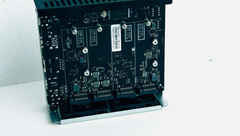 Circuit board with multiple blue connectors and electronic components mounted in a dark enclosure.