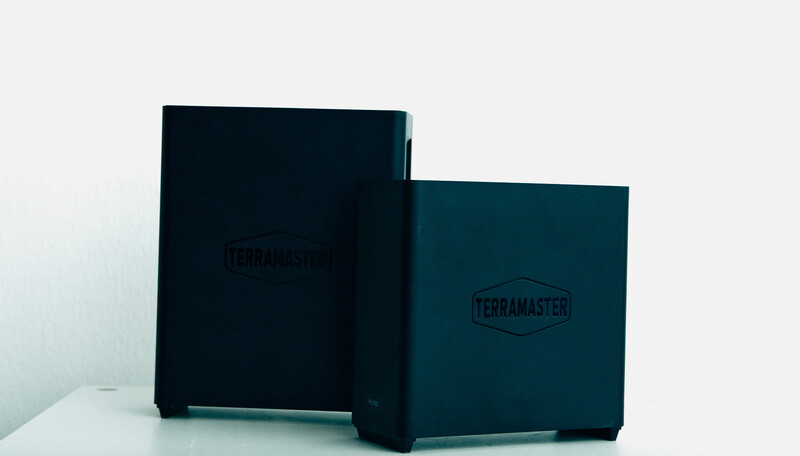 Two dark teal and navy boxes with embossed logos displayed against a white background.