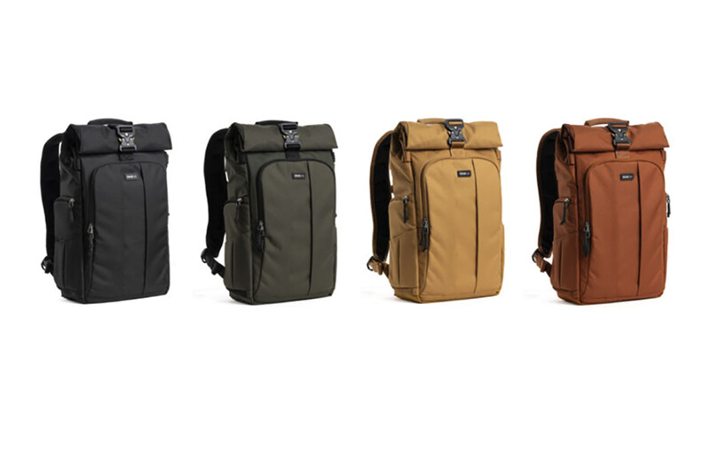 Four camera backpacks displayed in a row, shown in black, olive, tan, and rust colors.