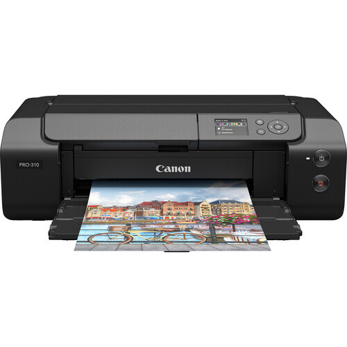 Canon PRO-100 inkjet printer with a colorful photograph of a coastal town partially ejected from the output tray.