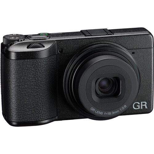 Ricoh GR compact digital camera with black textured body and fixed lens, shown at three-quarter angle.