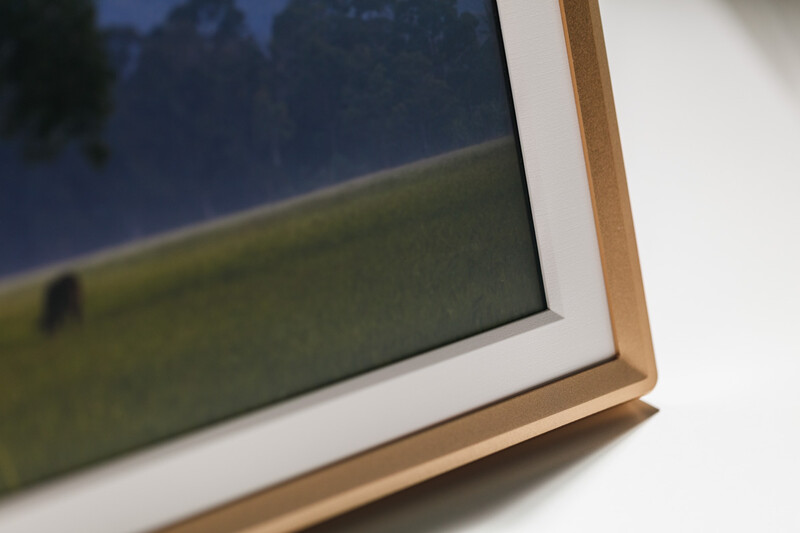 Framed photograph with natural wood border and white mat displayed at an angle.