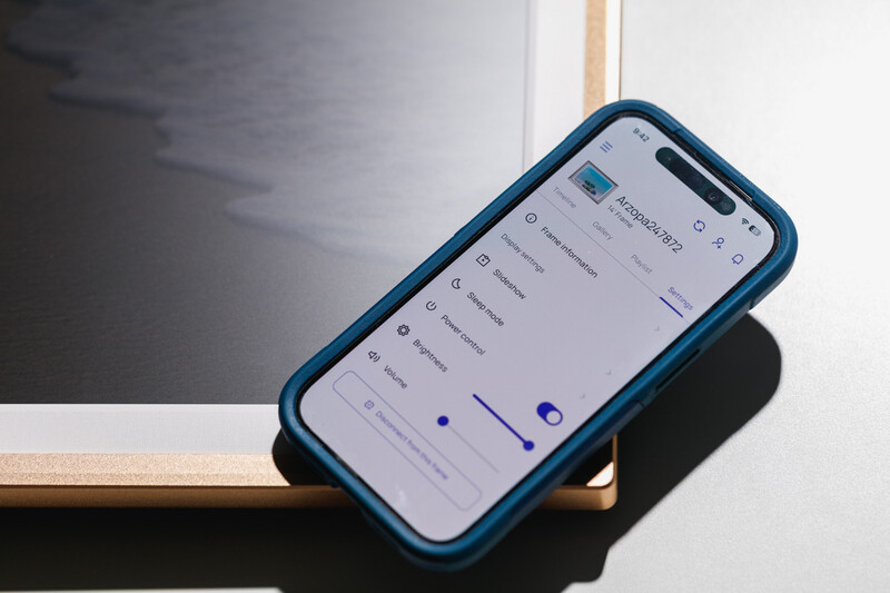 Smartphone with blue case displaying an app interface on a wooden surface with dramatic shadow.