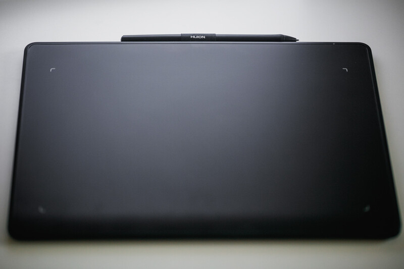Black tablet device photographed from above against a light gray background.
