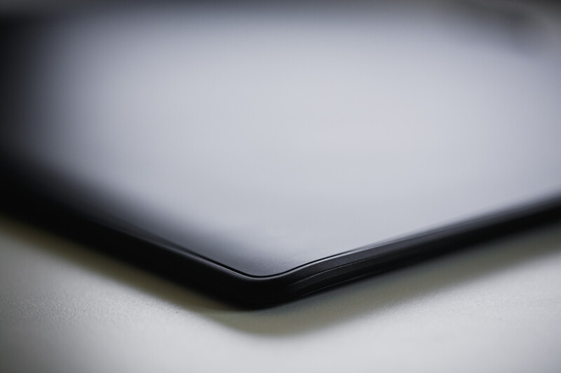 Closed laptop with metallic silver lid photographed from a close angle against a soft white background.