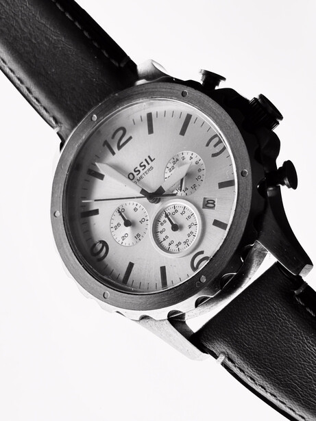 Chronograph watch with white dial and black leather strap, shot at an angle against white background.