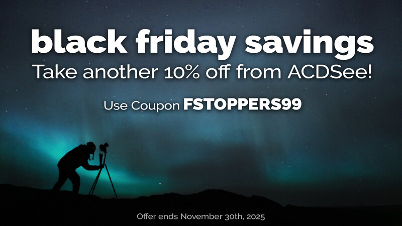 Silhouette of photographer with tripod against turquoise aurora borealis sky at night.