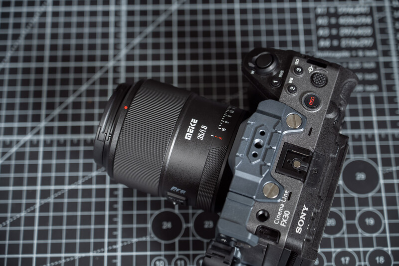 Mirrorless camera with attached lens on a gridded calibration chart background.