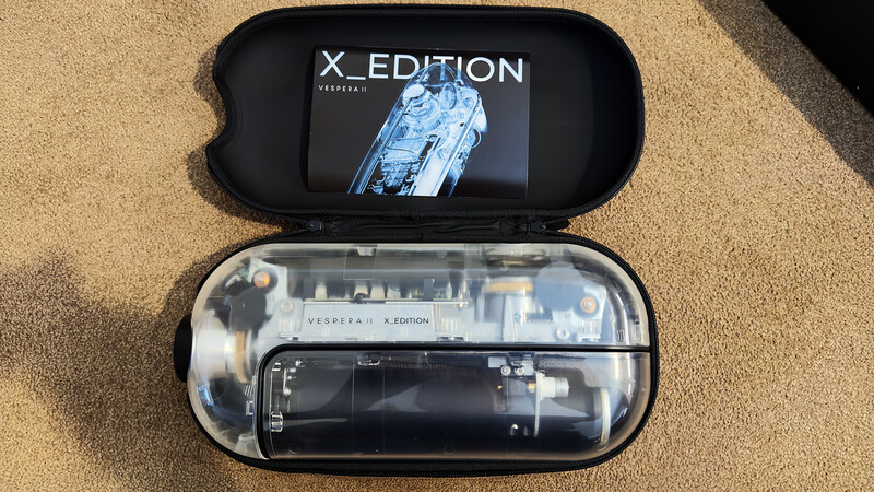 Vesper X Edition smartphone displayed in a black protective case with translucent design showing internal components.