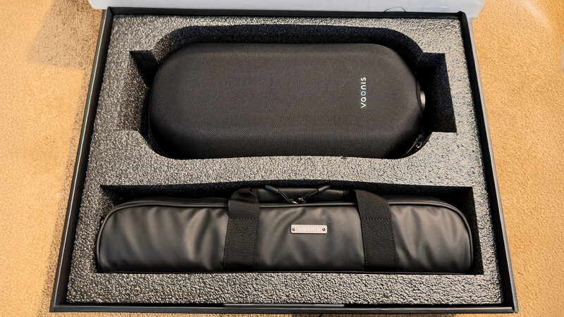 Two black camera lens cases nested in custom foam padding inside a black storage box.