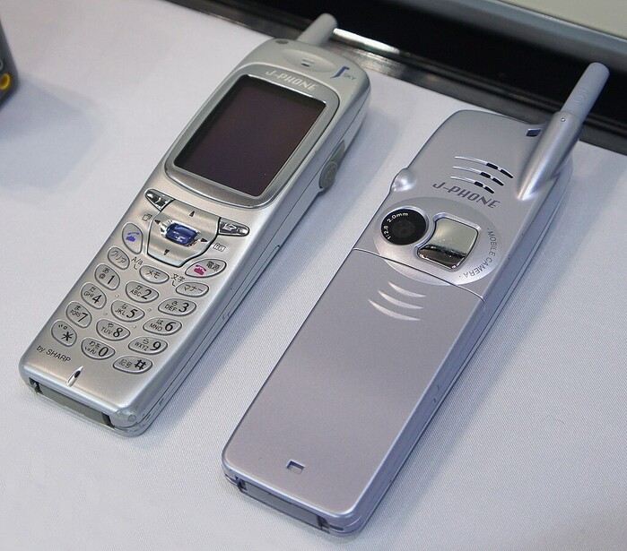 Two silver mobile phones from the early 2000s displayed side by side on a white surface.