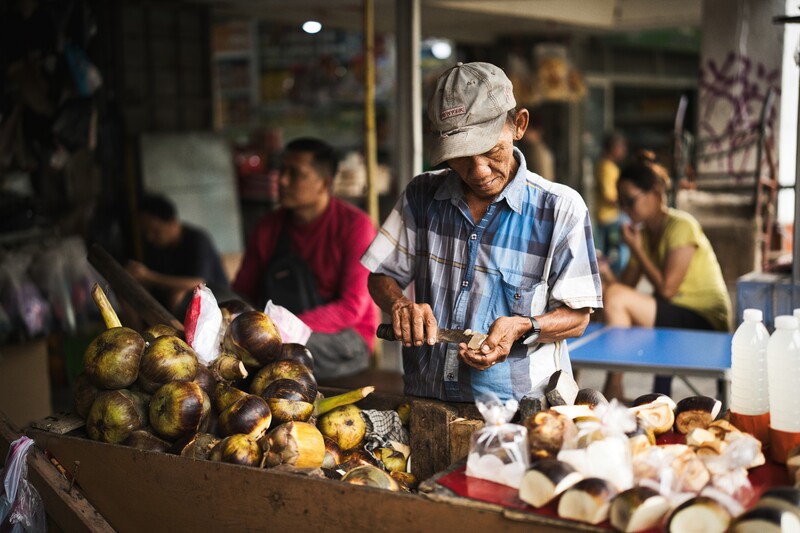 A wide, establishing shot of the fruit seller.