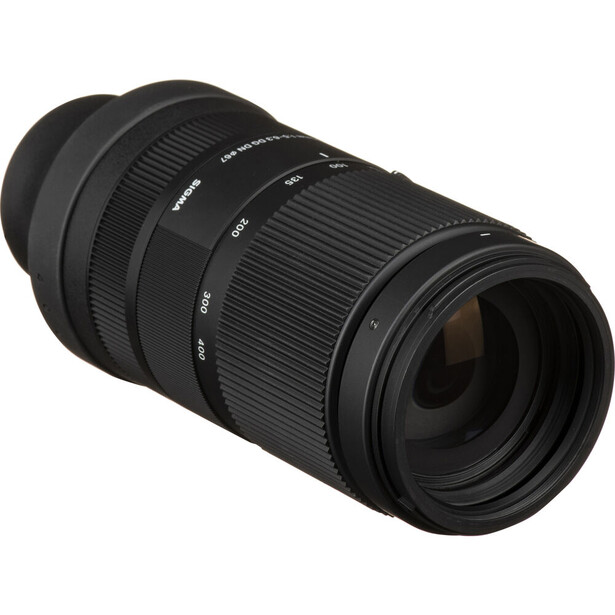 Black telephoto zoom lens with focus and zoom rings against white background.