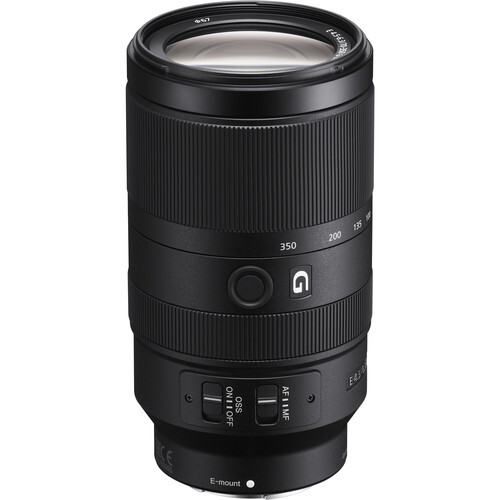 Black telephoto zoom lens with ribbed grip sections and control rings displayed against white background.