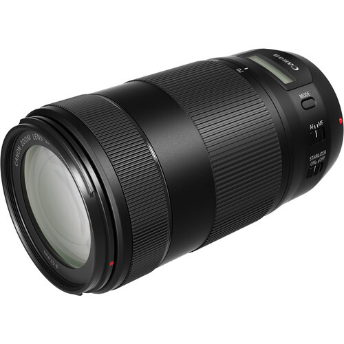 Black telephoto zoom lens with ribbed barrel and focus ring against white background.
