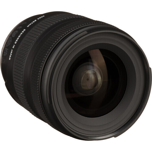 Black wide-angle camera lens viewed from the front, showing the large front element and focusing ring.