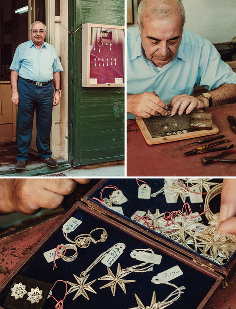 Jeweler examining detailed metalwork at a workbench with tools and jewelry displays.