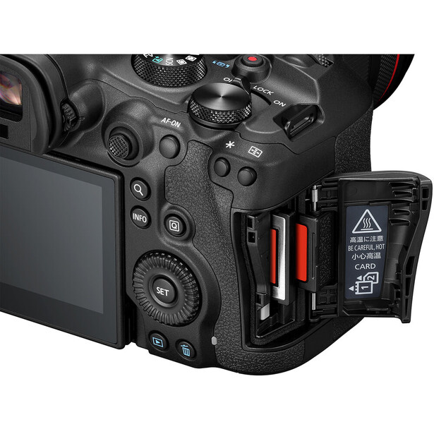 Professional mirrorless camera body with dual memory card slots open, showing red and black cards inserted.