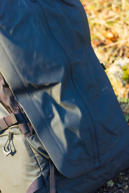 Close-up of a person wearing a blue jacket with a camera strap visible across their torso.