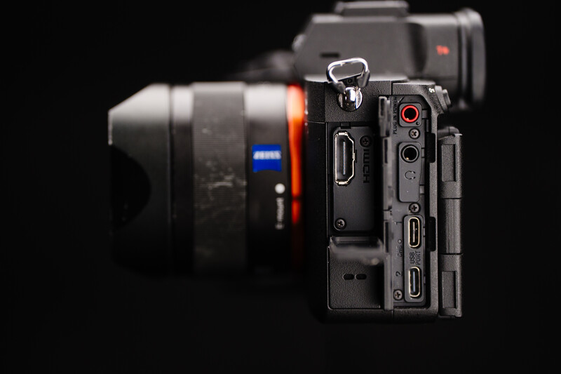 Sony mirrorless camera displayed from the side showing ports and controls against a black background.