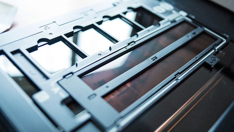Close-up of a camera's internal shutter mechanism and mirror assembly with metal framework and light-colored shutters.