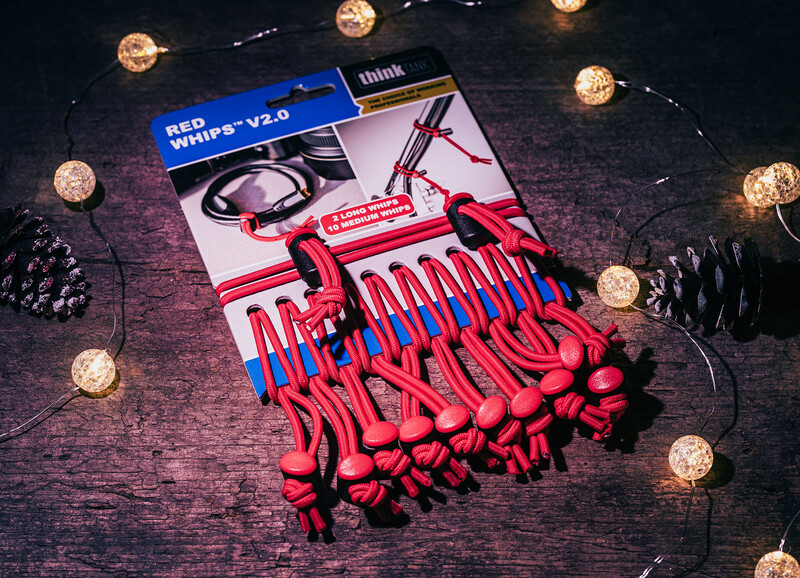 Red LED string lights and photography equipment arranged on dark textured surface with decorative elements.