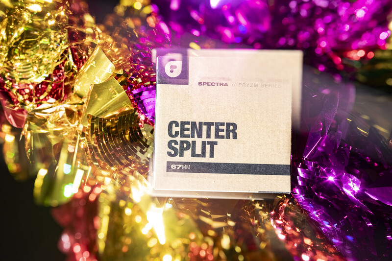 Spectra Center Split product box surrounded by gold and magenta bokeh lights and metallic confetti.
