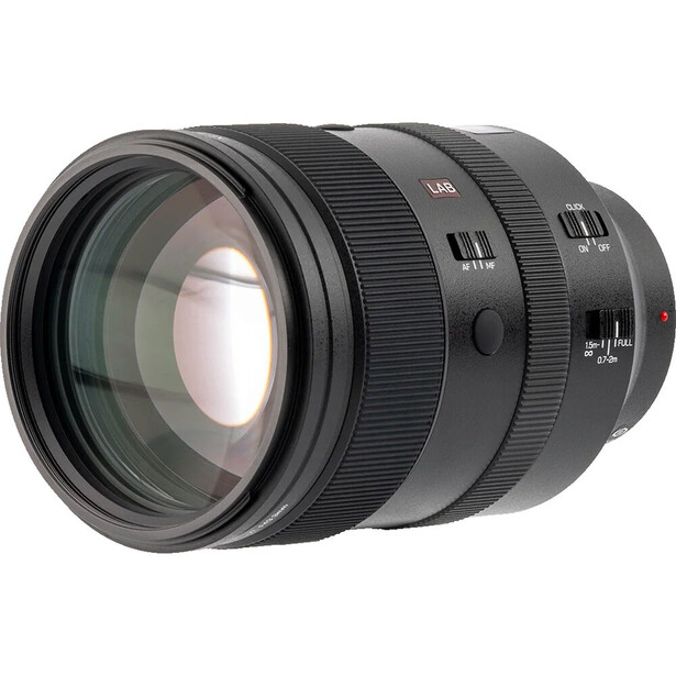 Fast telephoto zoom lens with glass elements visible through the front barrel against a white background.