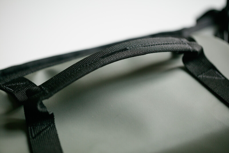Close-up of black fabric webbing and stitching detail on what appears to be camera gear or equipment strap.