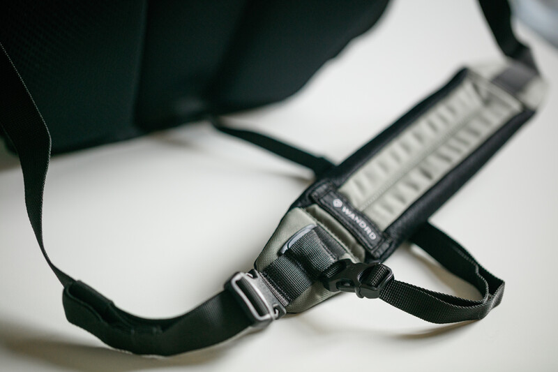 Close-up of a camera neck strap with metal buckle and adjustment slider on white surface.