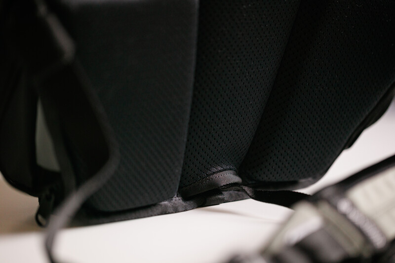 Close-up of black fabric with stitched seams and a gray label or tag detail.