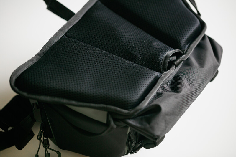 Open black camera bag with padded dividers and mesh pockets shown from above.