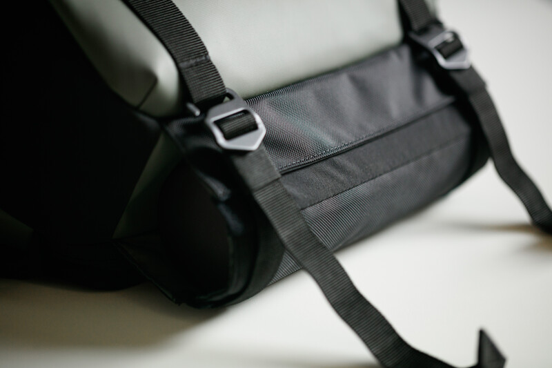 Black camera bag with padded compartments and adjustable shoulder straps on white surface.