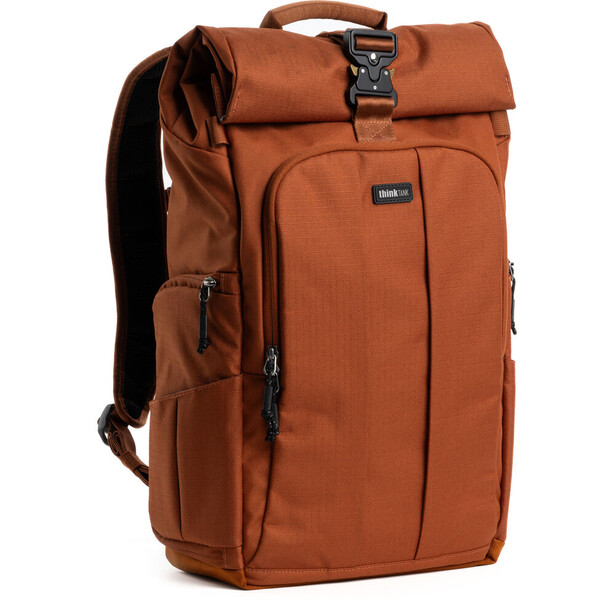 Rust-colored roll-top backpack with multiple compartments and padded straps displayed against white background.