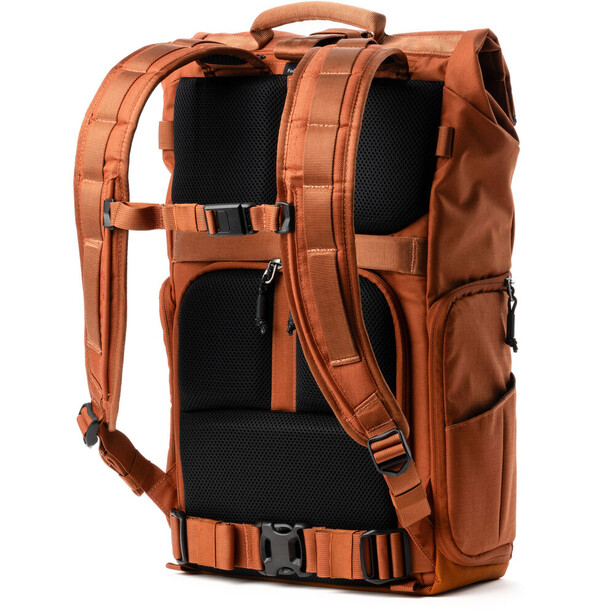 Orange canvas camera backpack displayed from rear showing padded straps and multiple compartments.