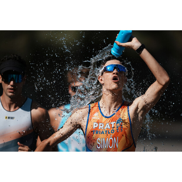 Runner in orange race bib doused with water during competition, captured mid-splash with dynamic motion.