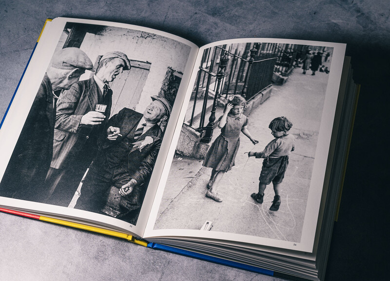Open book displaying two black and white photographs of children on city streets.