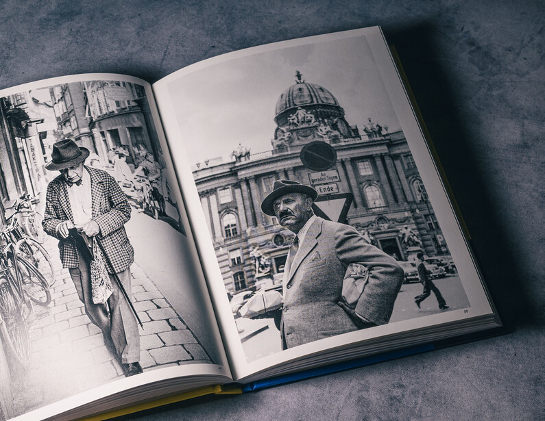 Open book displaying black and white photographs of urban architecture and street scenes.