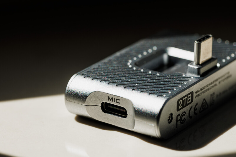 Close-up of a compact digital audio recorder showing the microphone input port and circuit board details.