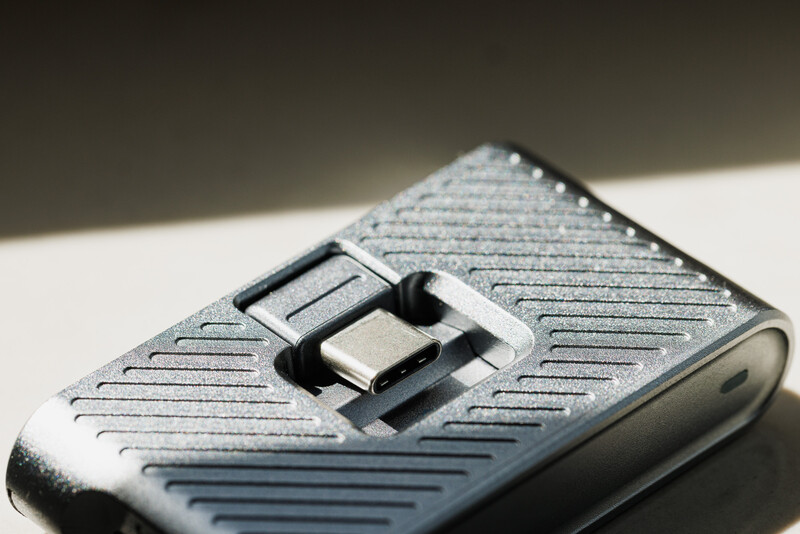 Close-up of a textured metallic flip phone with diagonal line pattern and chrome toggle switch.