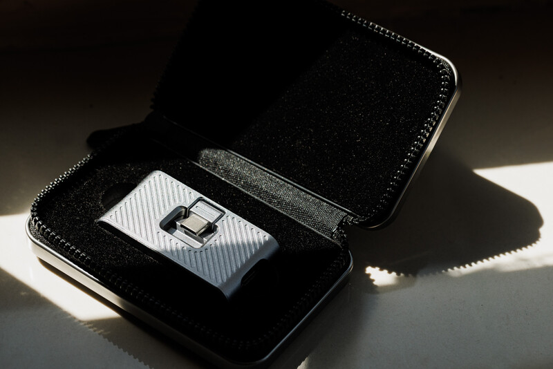 Luxury watch displayed in open black velvet jewelry box with white silk cushion, photographed in dramatic side lighting.